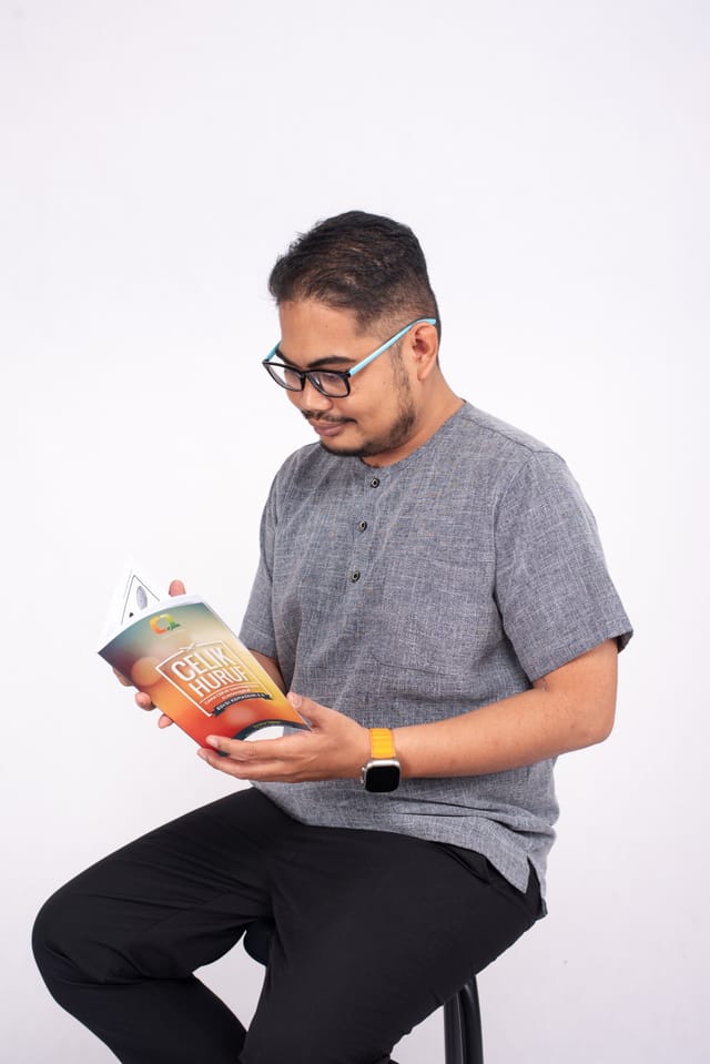 Syukur Sapuan membaca buku Celik Huruf
